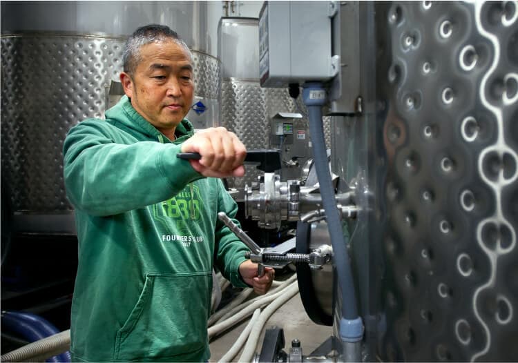Hayashi adjusting tank valves in the cellar
